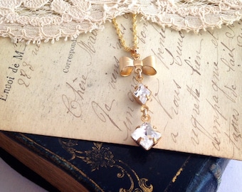 Golden necklace, ribbon bow and diamond-shaped charms in vintage glass from the 60s