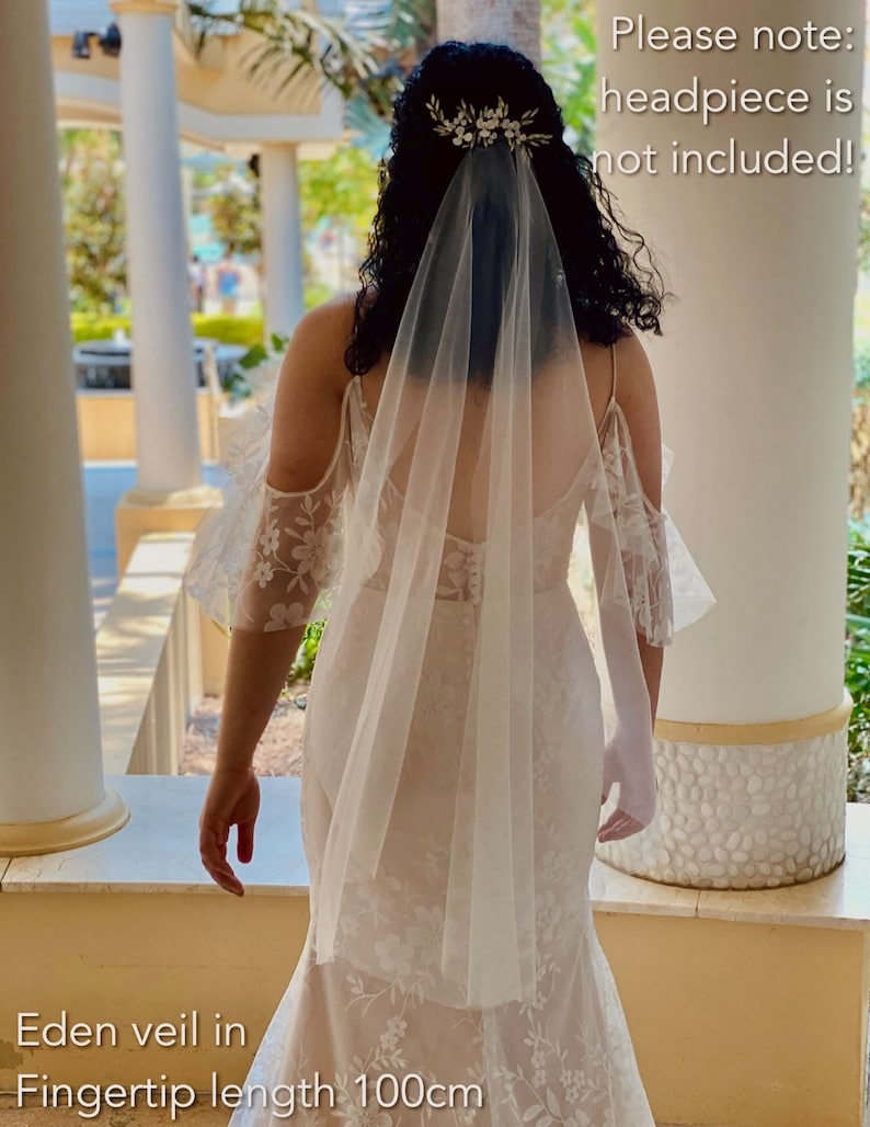 Bride is wearing a very fine, sheer veil. It is mid length which goes to the knees. It is made from fine quality tulle which is very soft to the touch. The veil is very sheer and allows the back details of the wedding dress to show through.