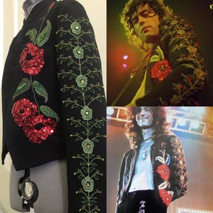 May include: A black jacket featuring vibrant red sequined floral embroidery on the front and intricate green vine and flower embroidery with small sequin accents along the sleeve, as seen in historical performance photographs of a musician.