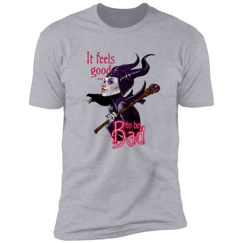 Puede incluir: Una camiseta gris jaspeada con una imagen de dibujos animados de Mal&eacute;fica de La Bella Durmiente de Disney. El texto "It feels good... to be Bad" est&aacute; impreso en la camiseta en rosa.
