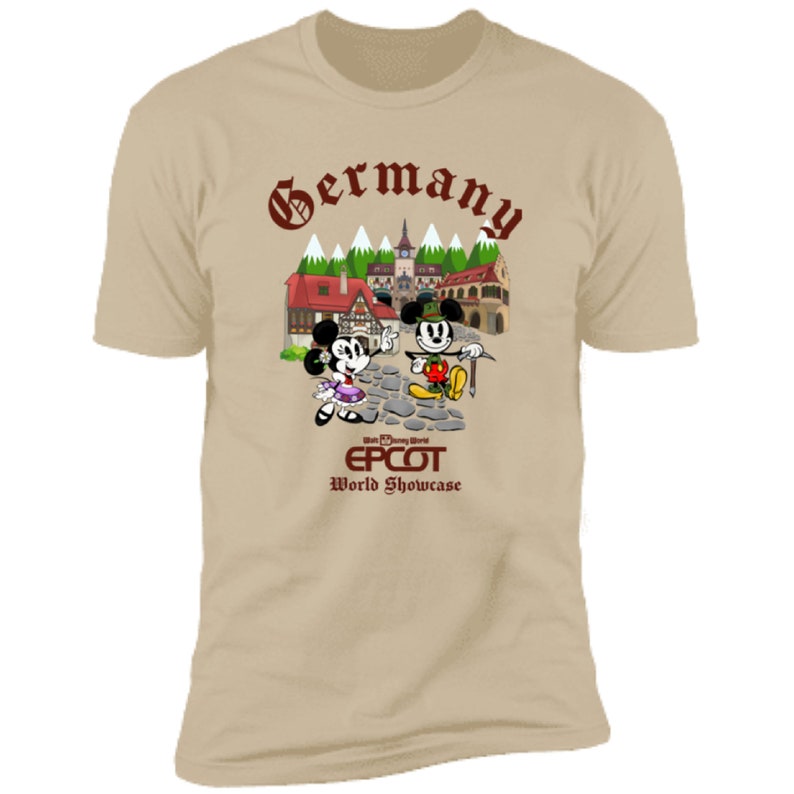 May include: A tan t-shirt with a brown graphic of Mickey and Minnie Mouse in German attire in front of a German village. The text "Germany" is at the top of the graphic, and the text "Walt Disney World EPCOT World Showcase" is at the bottom.