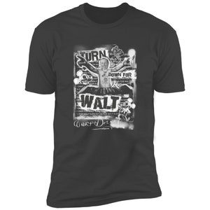 Puede incluir: Una camiseta negra con un estampado gr&aacute;fico blanco de Walt Disney. El gr&aacute;fico presenta una imagen en blanco y negro de Walt Disney con el texto "Turn Down For Walt" y "Warped Disney" en estilo graffiti.
