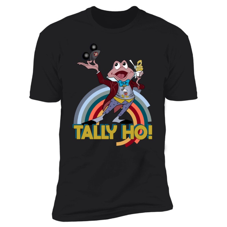 May include: Black t-shirt with a cartoon frog character in a red coat and bow tie, holding a dessert and juggling. The shirt has a rainbow design and the text "TALLY HO!" in yellow and blue.