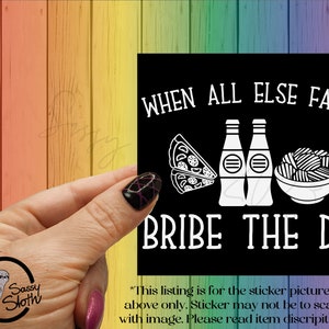 May include: Black and white sticker with the text "WHEN ALL ELSE FALLS BRIBE THE DM!"  The sticker features a pizza slice, two bottles of soda, and a bowl of noodles. The text "*This listing is for the sticker pictured above only. Sticker may not be to scale with image. Please read item description." is at the bottom of the sticker.