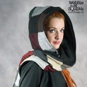 May include: A woman wearing a black hooded scarf with a patchwork design in shades of grey, brown, red, and white. The scarf is worn as a hood and a scarf. The brand name "Wobble & SouEak Clothing Co." is visible in the top right corner of the image.