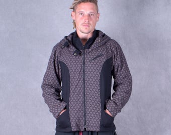 May include: A hooded jacket with a geometric pattern in shades of gray and black. The jacket has a full zipper, side pockets, and black panels on the sides. The model is wearing the jacket, with hands in the pockets.