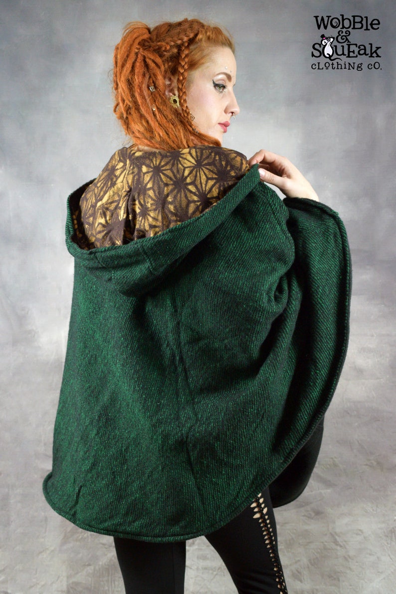 Puede incluir: Un poncho verde oscuro con capucha y forro estampado en dorado y marr&oacute;n. El poncho est&aacute; hecho de una tela suave y texturizada y tiene un corte holgado.