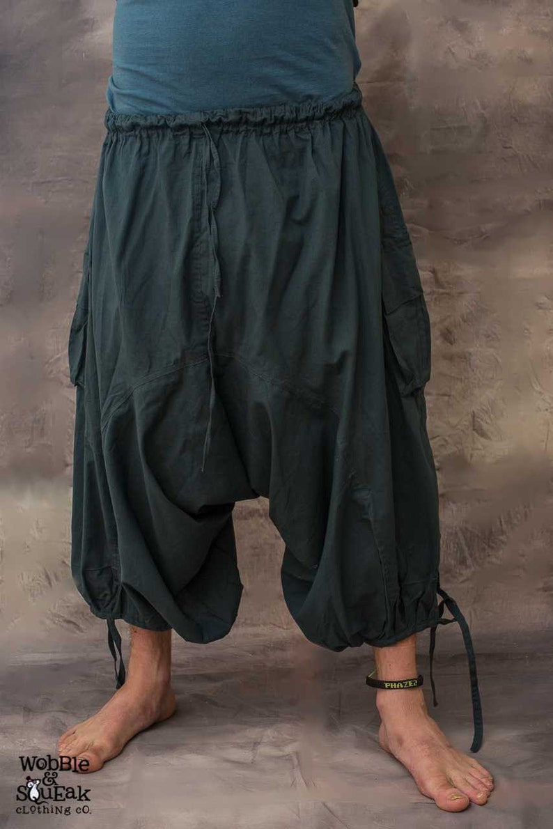 A pair of dark grey , loose-fitting trousers with a drawstring waist and side pockets. The trousers have a baggy, wide-leg style and are made of a soft, comfortable fabric.