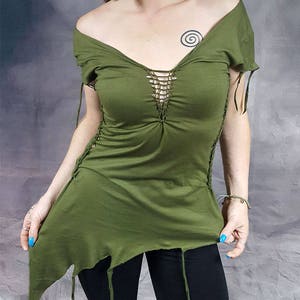 May include: A green, asymmetrical, short-sleeved shirt with a crocheted detail at the neckline. The shirt has a distressed look with frayed edges.
