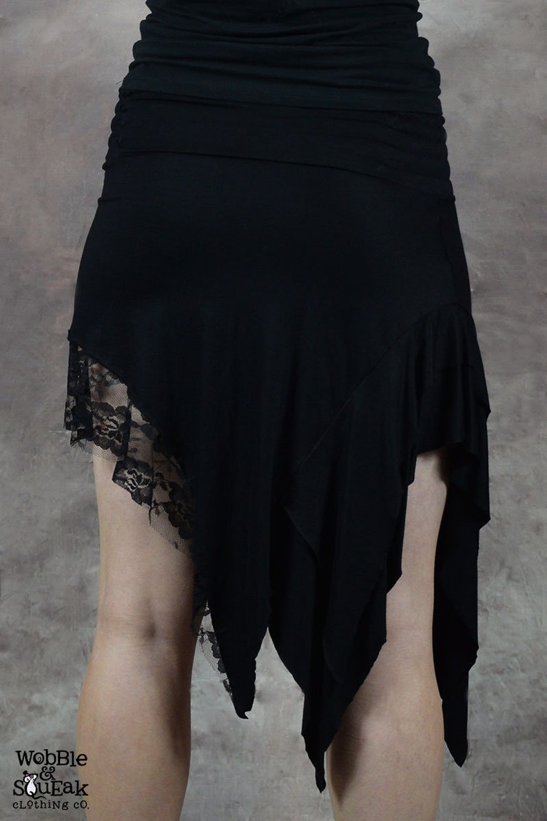 May include: Black asymmetrical skirt with a lace trim. The skirt is made of a soft, stretchy fabric and has a flowing, bohemian style.