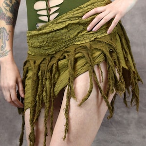 light yellow/green skirt with frayed edges and a tie closure. The skirt is made of a soft, lightweight fabric and has a flowy, bohemian style.