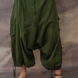 A pair of green cargo trousers with a drawstring waist and a loose, baggy fit. The trousers have two large cargo pockets on the sides and a smaller pocket on the back.