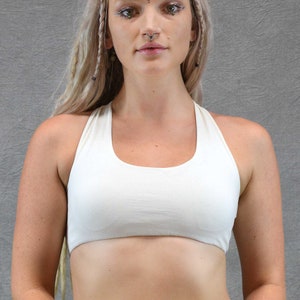 ​Front View off white ): Deep off white scoop neck yoga bra showing the supportive front fit and sleeveless artisanal design on a model