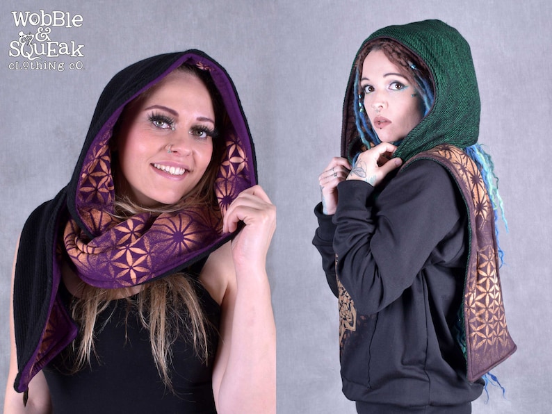 May include: Two people wearing black hoodies with a purple and gold patterned scarf. The scarf has a geometric design and is worn as a hood.