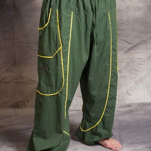 May include: Green trousers with yellow stitching. The trousers have a drawstring waist and large pockets on the sides.