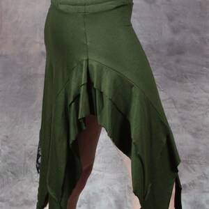 May include: A green asymmetrical skirt with a ruffled hem and a black lace trim. The skirt is made of a soft, stretchy fabric and has a comfortable fit.