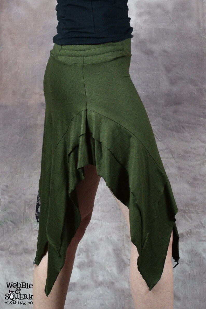 May include: A green asymmetrical skirt with a ruffled hem and a black lace trim. The skirt is made of a soft, stretchy fabric and has a comfortable fit.