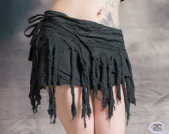 May include: Black skirt with frayed edges and a tie closure. The skirt is made of a soft, lightweight fabric and has a flowy, bohemian style.