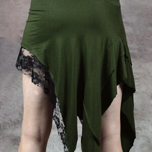 May include: A green asymmetrical skirt with black lace trim. The skirt is made of a soft, stretchy fabric and has a flowing, bohemian style.