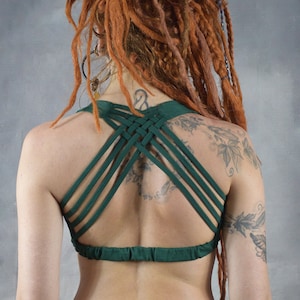 A green criss-cross back sports bra with a gathered band at the bottom. The bra is made of a soft, stretchy fabric and is perfect for yoga, pilates, or other workouts.