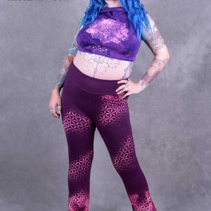 May include: Purple yoga pants with a geometric pattern and a tie-dye effect at the bottom. The pants are worn by a person with blue hair.