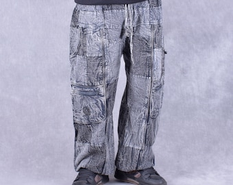 May include: Gray cargo pants with a distressed, patchwork design. The pants have multiple pockets and a drawstring waist.