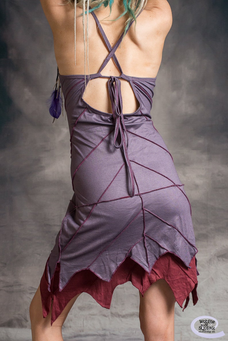May include: A purple and burgundy dress with a criss-cross back and a unique leaf-shaped hemline. The dress is made of a soft, flowing fabric and has a relaxed fit.