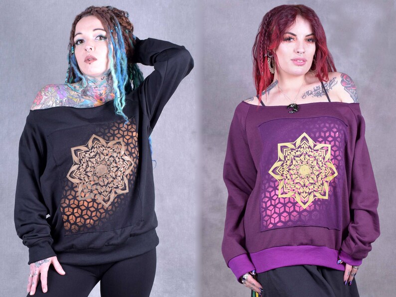 May include: Two off-the-shoulder sweatshirts with long sleeves and a geometric mandala design in gold on a black and purple background.