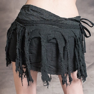 Black skirt with frayed edges and a tie closure. The skirt is made of a soft, lightweight fabric and has a flowy, bohemian style.