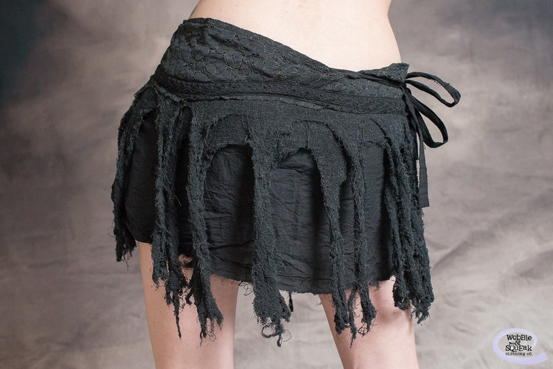 Black skirt with frayed edges and a tie closure. The skirt is made of a soft, lightweight fabric and has a flowy, bohemian style.