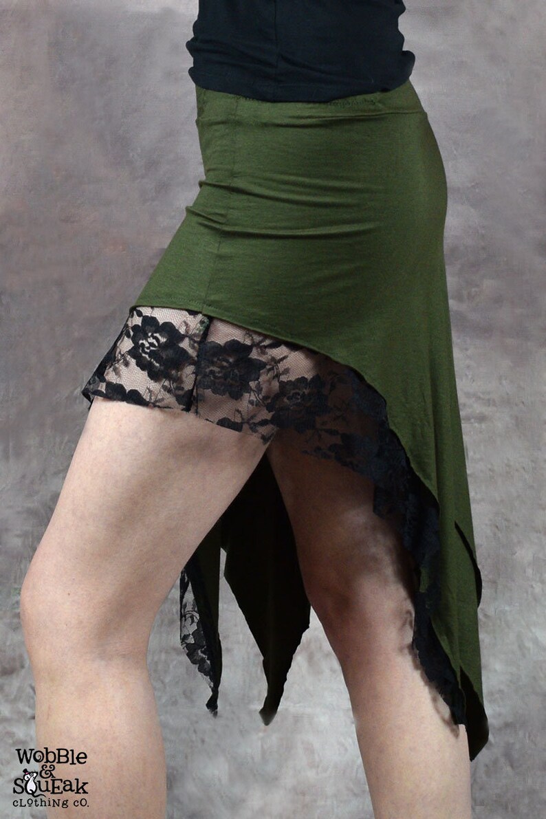May include: A green high-low skirt with black lace trim. The skirt is made of a soft, stretchy fabric and has a flowing, asymmetrical design.