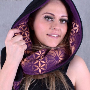 May include: A black hooded scarf with a purple lining and a geometric pattern in orange. The scarf is made of a soft, comfortable fabric and is perfect for keeping warm in the winter.