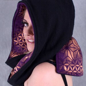 May include: Black hooded scarf with a purple and gold geometric pattern lining. The scarf is made of a soft, warm fabric and is perfect for keeping warm in the winter.