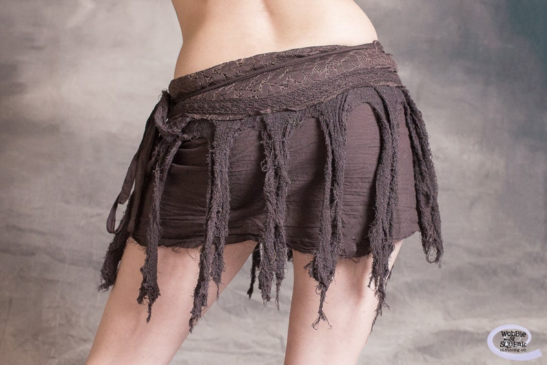 A brown, frayed, and layered skirt with a long, flowing fringe. The skirt is tied at the waist with a thick, brown fabric belt.