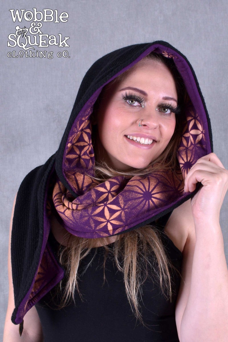 May include: A black hooded scarf with a purple lining and a geometric pattern. The scarf is made of a soft, comfortable fabric and is perfect for keeping warm in the winter.
