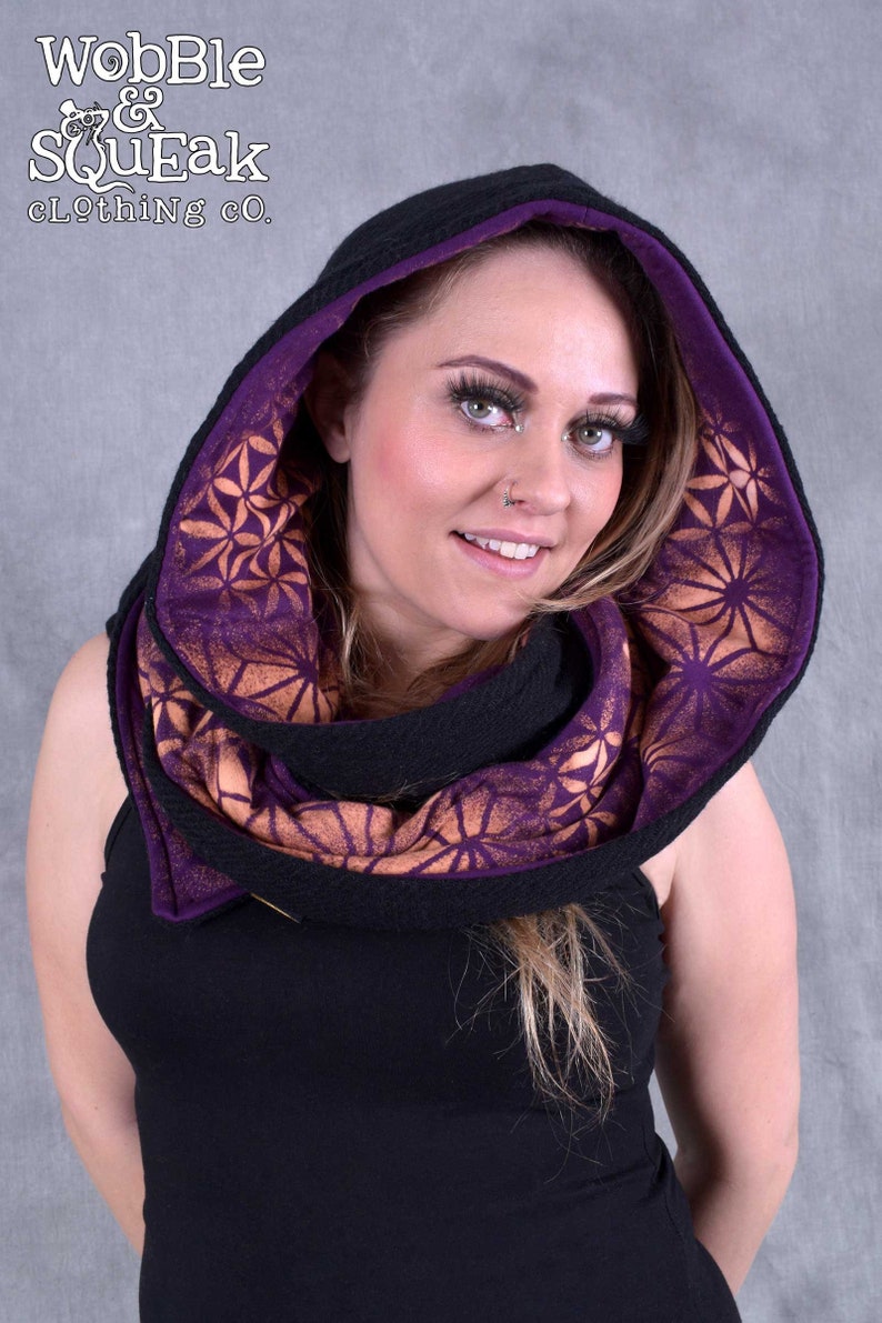 May include: A black hooded scarf with a purple and orange geometric pattern. The scarf is made of a soft, comfortable fabric and is perfect for keeping warm in the winter.