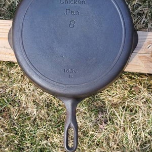 Puede incluir: Sartén de pollo de hierro fundido negro con el texto "Chicken Pan 8" y el número "1034" en la parte inferior.