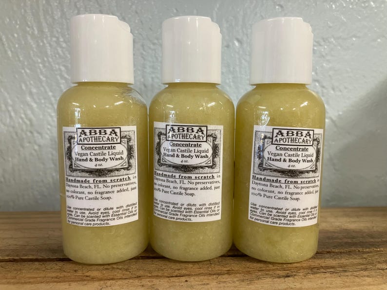 May include: Three amber glass bottles of vegan castile liquid hand and body wash. Each bottle is labeled "ABBA APOTHECARY Concentrate Vegan Castile Liquid Hand & Body Wash 4 oz. Handmade from scratch in Daytona Beach, FL. No preservatives, no colorant, no fragrance added, just 100% Pure Castile Soap."