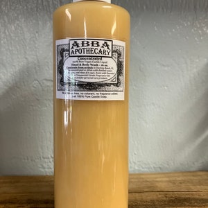May include: A clear amber glass bottle with a white label that reads "ABBA APOTHECARY Concentrated 100% Pure Vegan Castile Liquid Hand & Body Wash - 16 oz. Handmade from scratch in Daytona Beach, FL. The concentrated or dilute with distilled water. Cool rinse if in eyes. Scent with Essential Oils, not Commercial Grade Fragrance Oils. Intended for personal care products. No additives, no colorant, no fragrance added, just 100% Pure Castile Soap."