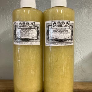 May include: Two clear plastic bottles of concentrated 100% pure vegan castile liquid hand and body wash from ABBA Apothecary. Each bottle is 16 ounces and made from scratch in Daytona Beach, Florida. The bottles are filled with a light yellow liquid.