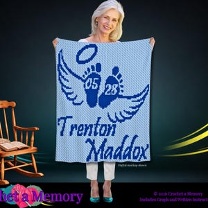May include: A light blue and dark blue crocheted blanket featuring a graphic of two baby footprints with wings and a halo above them. The numbers 05 and 28 are centered on the footprints, and the name Trenton Maddox is written in dark blue text.