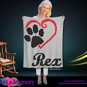 May include: A rectangular crochet blanket featuring a white background with a large black paw print outlined by a red heart. The name Rex is crocheted in black letters at the bottom. The text Digital mockup shown is printed in the lower right corner.