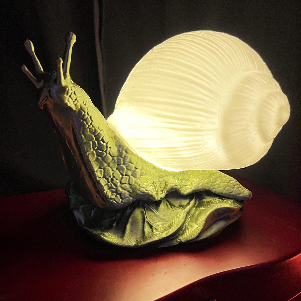 Whimsical 3D Printed Snail Lamp With Glow in the Dark Shell, Metallic green. White glow blue