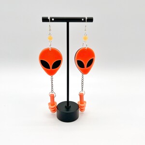 Pendientes con forma de cabeza de extraterrestre de color naranja neón, accesorios rave inusuales, atuendo para festival Kandi EDM, pendientes con bucle luminoso de luz negra UV para raveware.