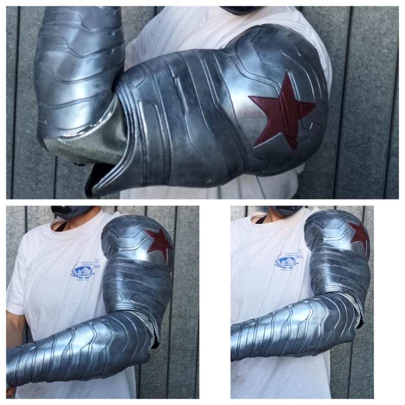May include: A silver and red robotic arm with a red star on the bicep. The arm is made of metal and has a textured surface.