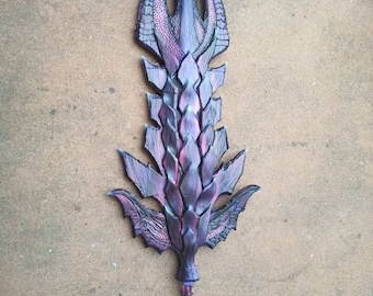 Könnte beinhalten: Ein schwarzes und violettes Fantasy-Schwert mit einem Drachenschuppen-Design. Das Schwert hat eine lange, dünne Klinge mit einer spitzen Spitze und einem dekorativen Griff.