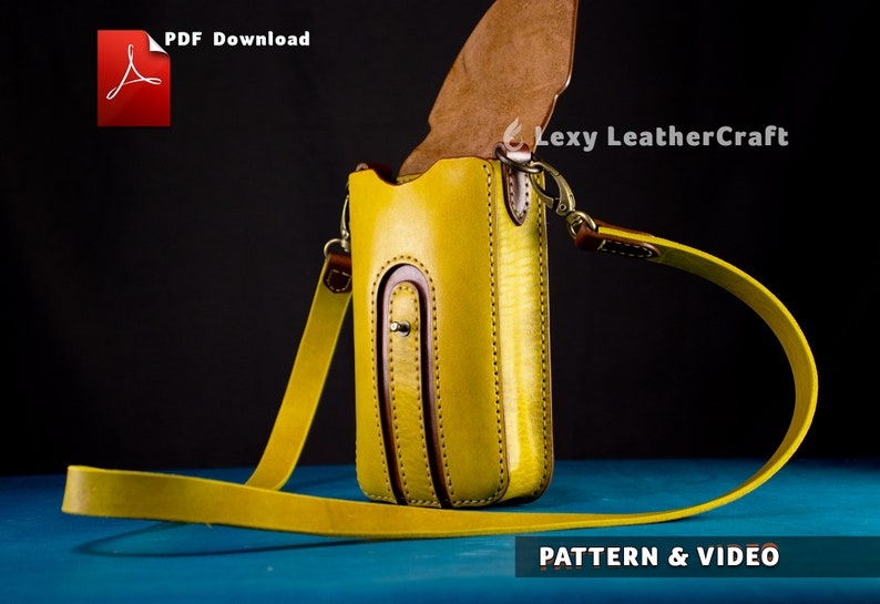 Puede incluir: Una funda de tel&eacute;fono de cuero amarillo con una solapa de cuero marr&oacute;n y una correa amarilla. La funda tiene un peque&ntilde;o bolsillo en la parte delantera y se cierra con un broche a presi&oacute;n. La correa es ajustable y tiene un cierre de metal. La funda est&aacute; sobre una superficie azul. "PDF Download" y "Lexy LeatherCraft" son visibles en la imagen.