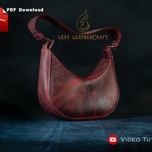 May include: A burgundy leather crescent-shaped handbag with a shoulder strap. The bag features visible stitching and a zipper closure. The image includes the text "PDF Download" and "Video Tutorial". The brand name "Lexy Leathercraft" is also visible.