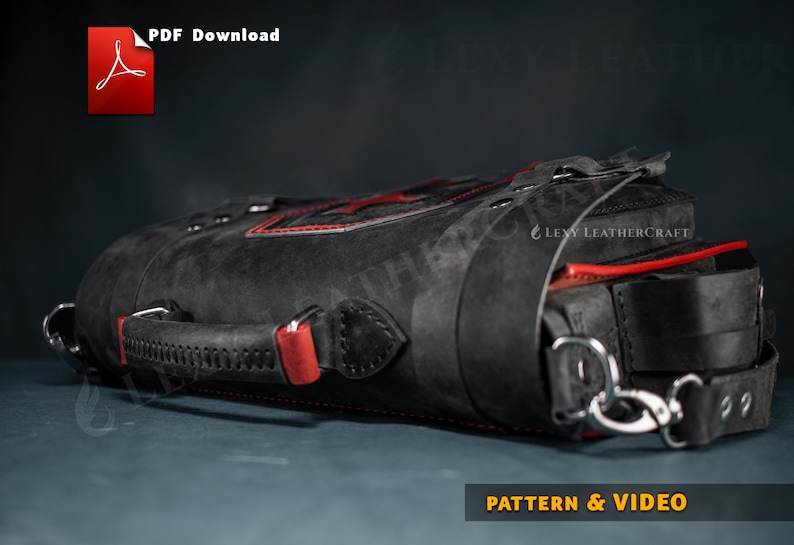Puede incluir: Bolso de cuero negro con costuras rojas y un asa de cuero roja. El bolso tiene una hebilla de metal y una correa con un cierre de metal. El bolso est&aacute; sobre una superficie gris. "LEVY LEATHERCRAFT" est&aacute; impreso en el bolso.