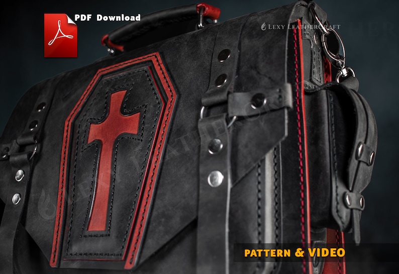 Puede incluir: Bolso de cuero negro con una cruz roja en la parte delantera. El bolso tiene detalles de costura roja y una hebilla plateada. El bolso est&aacute; etiquetado como "PATTERN & VIDEO".